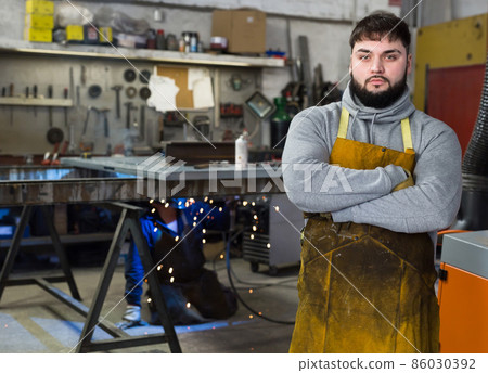 Blacksmith in metalworking workshop Blacksmith in metalworking workshop 86030392