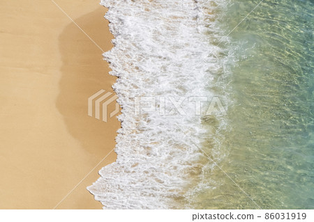 Beautiful empty beach from above with turquoise sea water and clean sand. Sea foam and waves. 86031919