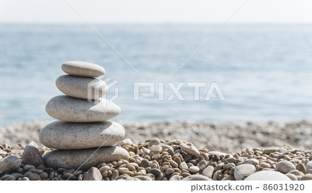 Zen relax background. A pyramid of stones on the beach in clear sunny weather. Background for meditation, yoga and massage 86031920