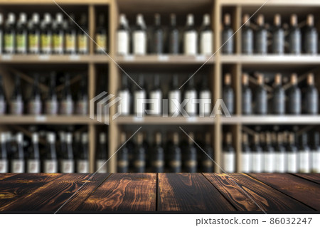 Wine wooden table background. Blurred wine shop with bottles on the counter. 86032247