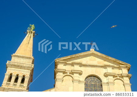 The Tower of The Church of St. Euphemia on the background of blue sky in Rovinj, Croatia.  86033311