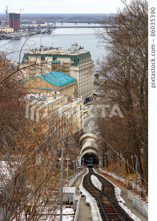 Mountain slope overlooking the Kyiv funicular, the Dnipro river and the winter cityscape. Mountain slope overlooking the Kyiv funicular, the Dnipro river and the winter cityscape. 86035390