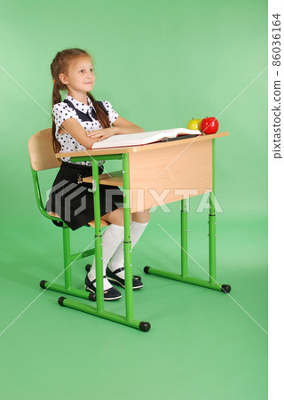 Girl in a school uniform sitting at a desk and... - Stock Photo ...