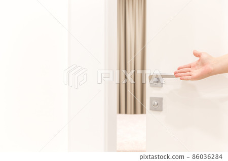 Woman's hand opening door in bedroom Woman's hand opening door in bedroom 86036284
