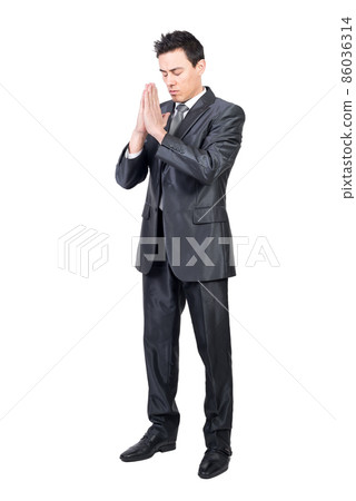 Serene man in suit praying with closed eyes 86036314