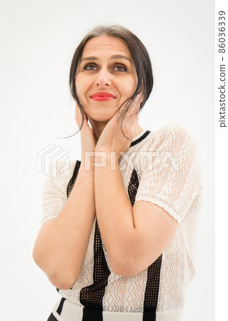 Studio photo of middle aged woman starting getting grey-haired wearing black and white clothes on white background, middle age sexy lady, happy life concept 86036339