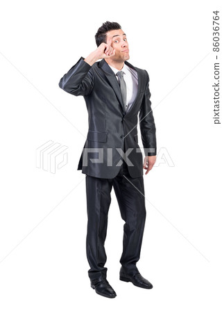 Smart businessman touching temple in studio. White background. Smart businessman touching temple in studio. White background. 86036764