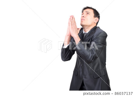 Young male manager in formal suit praying 86037137