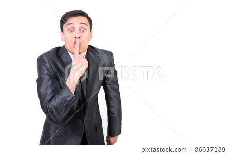 Man in formal suit covering mouth with finger Man in formal suit covering mouth with finger 86037189