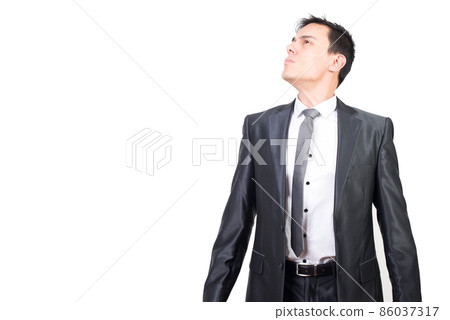 Honest young businessman looking away in white studio 86037317