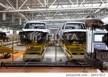 Photo of automobile production line. Modern car assembly plant. Auto industry. Interior of a high Photo of automobile production line. Modern car assembly plant. Auto industry. Interior of a high 86037837