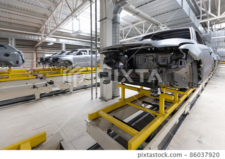 Car bodies are on assembly line. Factory for production of cars. Modern automotive industry Car bodies are on assembly line. Factory for production of cars. Modern automotive industry 86037920