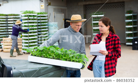 Farmers talking near car at plant nursery 86038352