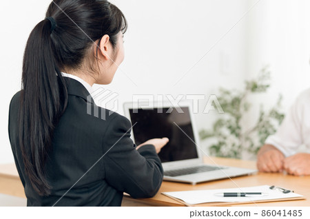A woman in a suit and an elderly man having a meeting 86041485