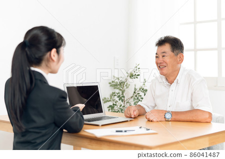 A woman in a suit and an elderly man having a meeting 86041487
