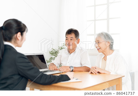 一個穿西裝的女人和一對老夫婦在電腦上解釋 86041737