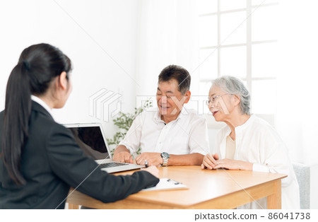 一個穿西裝的女人和一對老夫婦在電腦上解釋 86041738