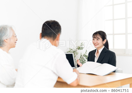 一個穿西裝的女人和一對老夫婦在電腦上解釋 一個穿西裝的女人和一對老夫婦在電腦上解釋 86041751