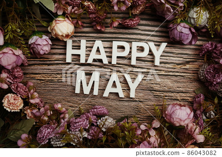Happy May alphabet letters with flowers frame on wooden background Happy May alphabet letters with flowers frame on wooden background 86043082