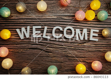 Welcome alphabet letters decorate with LED cotton balls on wooden background Welcome alphabet letters decorate with LED cotton balls on wooden background 86043113