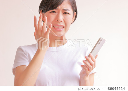 A woman with a regrettable expression with a smartphone 1 A woman with a regrettable expression with a smartphone 1 86043614