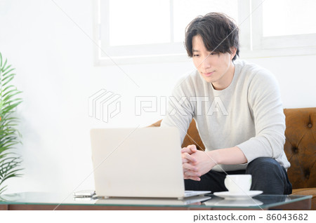 A man using a computer at home - Stock Photo [86043682] - PIXTA