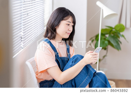 一個操作智能手機的年輕女子 86043892