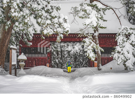 Worshipers (Torii and worshipers) worshiping at a snow-covered shrine 86049902