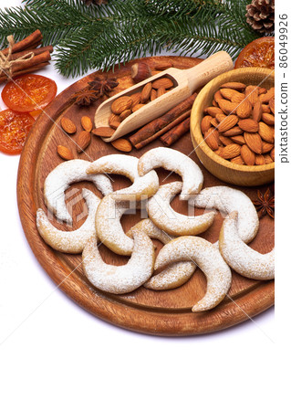 German or Austrian Vanillekipferl vanilla kipferl cookies and almond nuts on wooden serving board German or Austrian Vanillekipferl vanilla kipferl cookies and almond nuts on wooden serving board 86049926