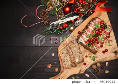 Traditional French terrine covered with bacon on dark wooden background with Christmas decorations 86049933