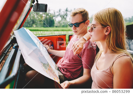 Trendy concentrated couple with map in car 86053299