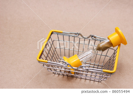An hourglass in the shopping basket. concept of time. An hourglass in the shopping basket. concept of time. 86055494