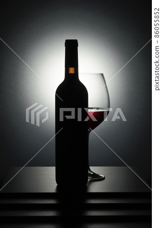 Bottle and glass of red wine. 86055852