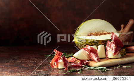 Juicy melon with prosciutto and rosemary. Juicy melon with prosciutto and rosemary. 86055864