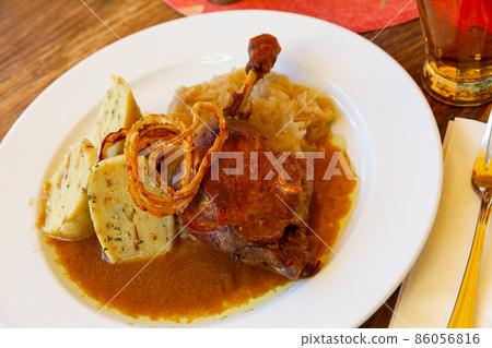 Confit duck leg with sauerkraut and dumplings Confit duck leg with sauerkraut and dumplings 86056816