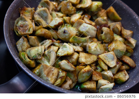 Frying chopped artichokes Frying chopped artichokes 86056976