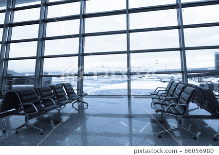 Empty seats at departure lounge, no people. International airport interior Empty seats at departure lounge, no people. International airport interior 86056980