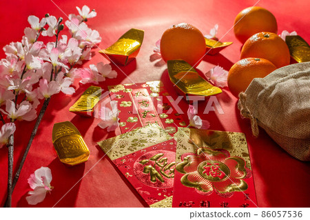 Above view accessories of Chinese new year or Mood day festival oranges gold and Angpao pockets whit cherry blossom branch decorations. Above view accessories of Chinese new year or Mood day festival oranges gold and Angpao pockets whit cherry blossom branch decorations. 86057536