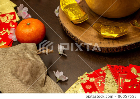 Above view accessories of Chinese new year or Mood day festival oranges gold and Angpao pockets whit cherry blossom branch decorations. Above view accessories of Chinese new year or Mood day festival oranges gold and Angpao pockets whit cherry blossom branch decorations. 86057555