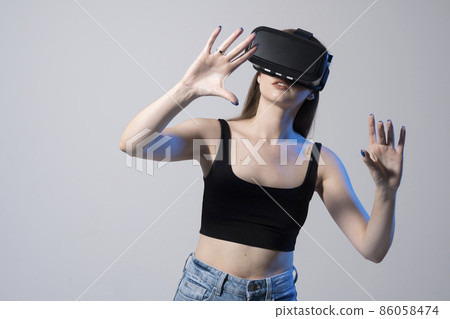 Happy brunette girl getting experience using VR headset glasses of virtual reality. Happy brunette girl getting experience using VR headset glasses of virtual reality. 86058474