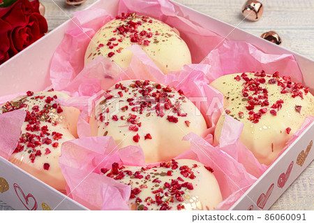 Handmade gingerbread in white chocolate on a light background. Festive packaging. 86060091