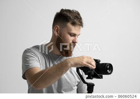 Videography, filmmaking and creativity concept. Portraite of videographer with a camera and gimbal. Professional video equipment. Portraite of cinematographer. 86060524