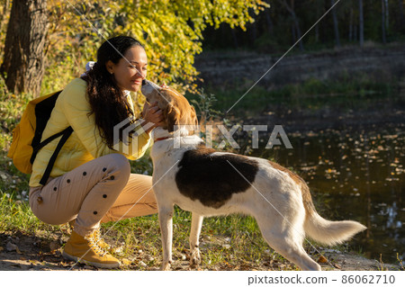 Young woman takes a hike with her dog. 86062710