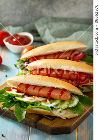 Traditional american fast food. Barbecue grilled Hot dog with fresh vegetables on wooden table with copy space. 86062976
