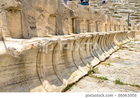 Stone seats of Theater of Dionysus near Acropolis, Athens, Greece. Marble chairs with owners names inscription. Stone seats of Theater of Dionysus near Acropolis, Athens, Greece. Marble chairs with owners names inscription. 86063008