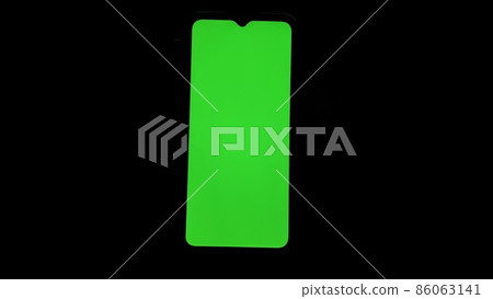 Chroma key on electronic devices, phone and monitor, green screen and hand scrolling through the screen in the absence of light 86063141
