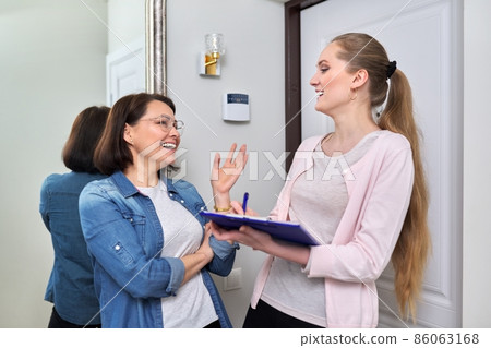 Female social worker talking to middle aged woman at home Female social worker talking to middle aged woman at home 86063168