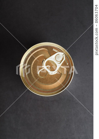 The lid of a metal tin can on a black background 86063704