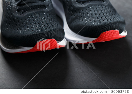 Black sports sneakers for training on a dark background Black sports sneakers for training on a dark background 86063758