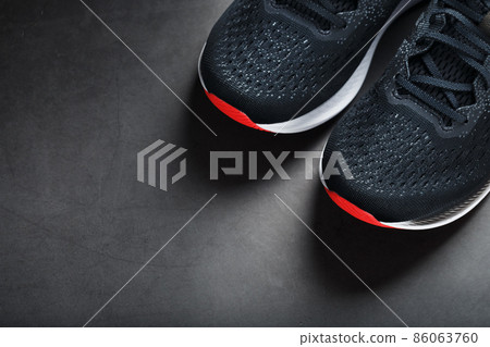 Black sports sneakers with red soles on a black background. Black sports sneakers with red soles on a black background. 86063760